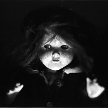 Creepy doll in dark lighting.